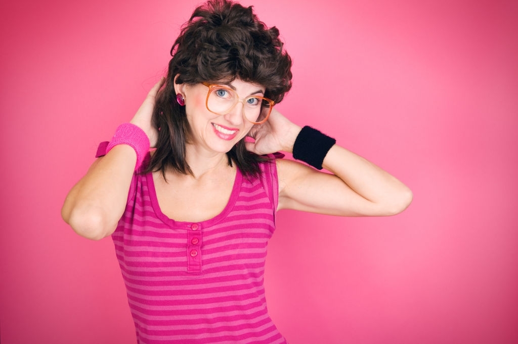 A humorous image of a woman dressed in 80's fashion including the popular mullet hairstyle.