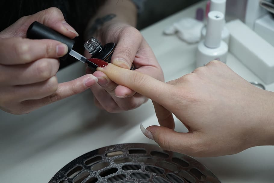 woman getting gel manicure at nail salon